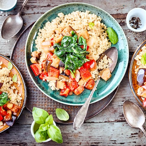 Quinoa-Ratatouille: Probieren Sie unser veganes Gericht mit Auberginen-Paprikagemüse, Babyspinat und Tomaten, gewürzt mit Knoblauch und Basilikum!