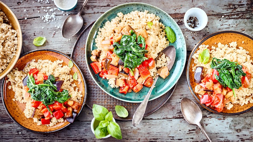 Quinoa-Ratatouille: Probieren Sie unser veganes Gericht mit Auberginen-Paprikagemüse, Babyspinat und Tomaten, gewürzt mit Knoblauch und Basilikum!