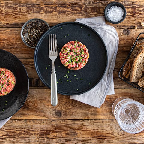 Selbstgemachtes Rindertatar aus Rinderfilet, Schnittlauch, Kapern, Schalotten und Cornichons – am besten serviert auf frischem Bauernbrot.