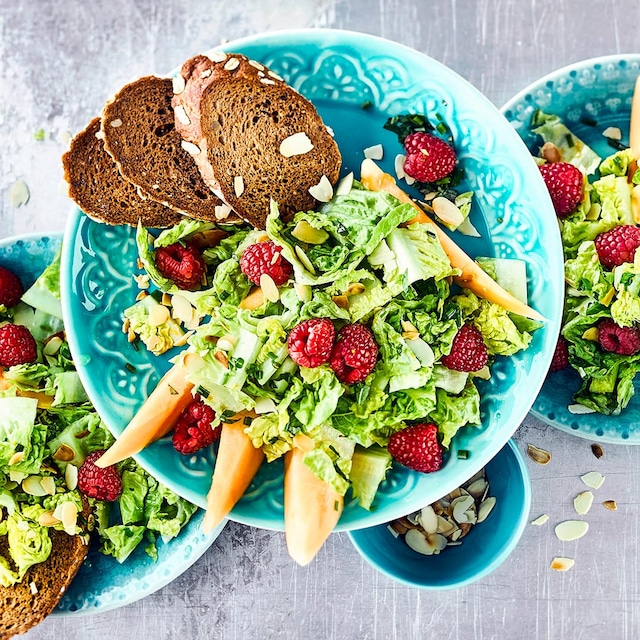 In nur zehn Minuten fertig – unser leckerer Salat mit Himbeeren, Mandeln und Charentais-Melone mit fruchtigem Orangen-Dressing! 