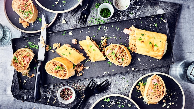 Unser Tipp für ein deftiges Wintergericht: Probieren Sie unseren selbst gemachten, herzhaften Strudel gefüllt mit Sauerkraut, saftigem Kassler und Möhren! 