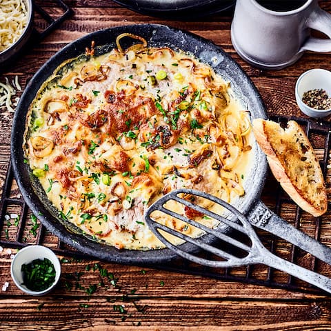 Lust auf ein deftiges Fleischgericht? Probieren Sie unser Rezept für Schweineschnitzel in Zwiebel-Sahne-Soße aus: Mit Kräuter Creme fraiche, Knoblauch, geriebenem Käse und einem Schuss Weißwein!