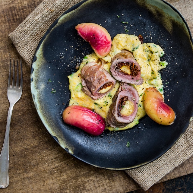 Italienische Schnitzelröllchen mit Parmaschinken und getrockneten Tomaten. Dazu eine cremige Polenta und marinierte Plattpfirsich-Hälften – einfach köstlich.