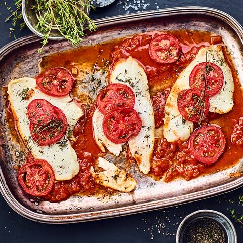 Für Fischliebhaber: Unser Rezept für Scholle im Ofen gebacken auf Tomaten-Knoblauch-Beet mit einem Schuss Weißwein und Thymian – probieren Sie es aus!