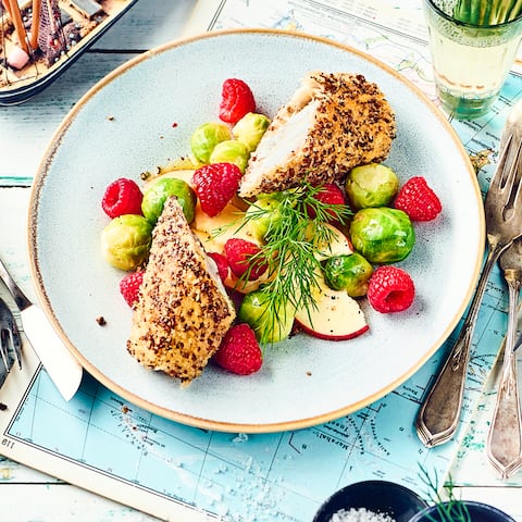 Knusprige Schwarzbrotkruste, saftiges Fischfilet: Probieren Sie unser Rezept für paniertes Seelachsfilet aus! Dazu gibt's Rosenkohlsalat mit Äpfeln und feinem Ingwer-Dressing.