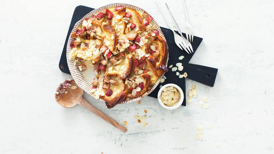 Sommerlicher Ofenschlupfer: Probieren Sie unseren süßen Brioche-Auflauf mit frischem Rhabarber und Mandelblättchen - als Hauptspeise oder Dessert!