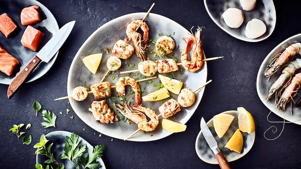 Mögen Sie die portugiesische Küche? Dann probieren Sie unsere Tapas mit Meeresfrüchten: Lachsfilet, Garnelen und Jakobsmuscheln in einer Marinade aus Zitronensaft, Oregano und Öl am Spieß gegrillt - pikant und lecker!v