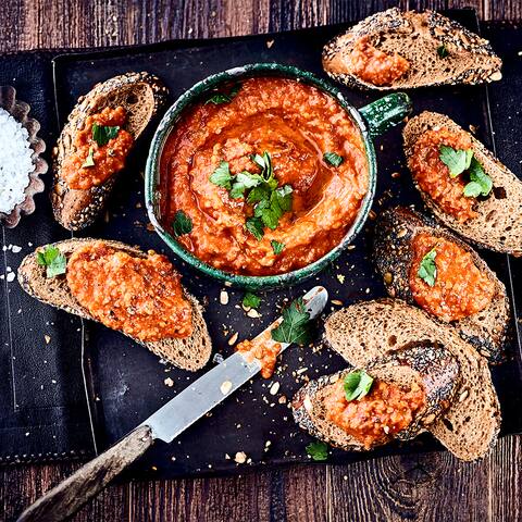 Diese rote Olivenpaste hat ihren Ursprung in Südfrankreich und schmeckt gut zu frischem Brot: Probieren Sie unsere Tapenade à la Tomate mit Knoblauch, Thymian und Sardellenfilets – pikant und lecker!