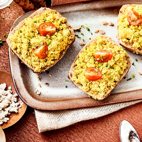 Sie möchten sich ein rein veganes Tofu-Frühstück zubereiten? Dann testen Sie unser Tofu-Rührei-Rezept mit Kurkuma, Tomaten und Mandelmus!
