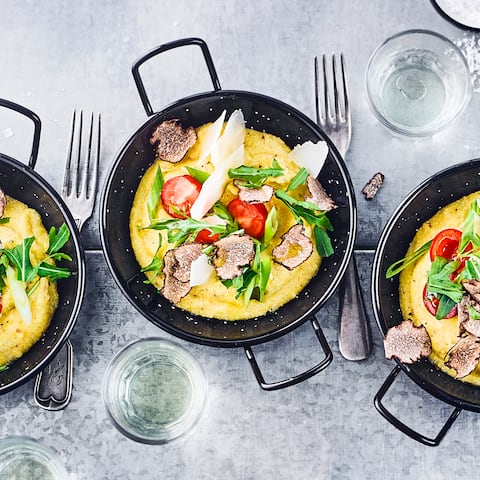 Verwöhnen Sie Ihre Gäste mit unserem edlen aber trotzdem schnellen Rezept für Trüffel-Polenta mit Rucola, Cocktailtomaten und Parmesan – gleich ausprobieren!