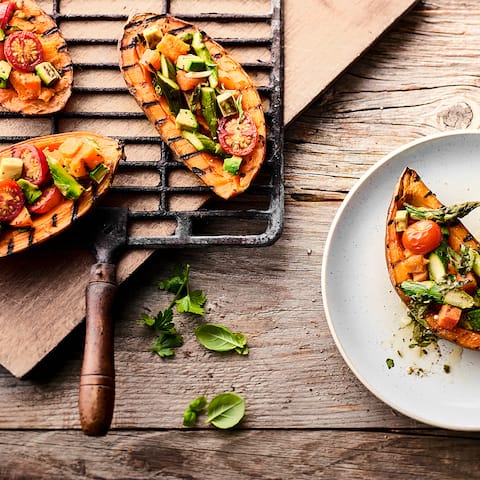 Eine fantastische Beilage, die Sie so vielleicht noch nicht probiert haben: Süßkartoffel vom Grill mit Tomaten-Avocado-Spargel-Topping und selbstgemachter Kräutersoße.