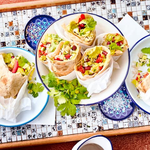 Selbst gemachte Tortillas, gefüllt mit frischem Gemüse, Guacamole, Bohnen und Reis. Ein besonderer Genuss. Probieren Sie unsere veganen mexikanischen Wraps.
