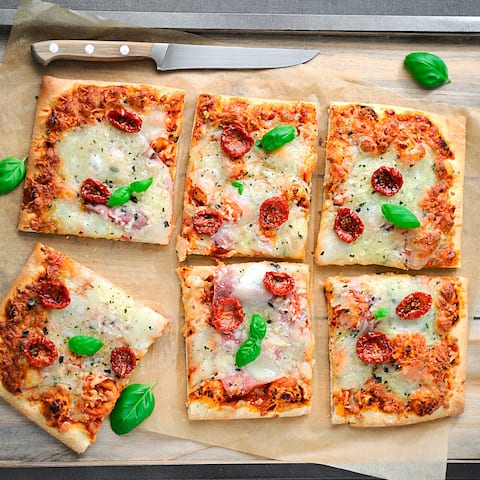 Unsere selbst gebackene vegetarische Pizza mit Tomaten, Mozzarella und Basilikum schmeckt der ganzen Familie und verspricht viel Spaß beim Belegen!