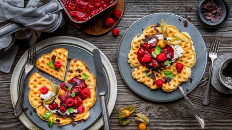 Es ist Waffelzeit! Herrlich nach warmer Butter und Zucker duftend und mit einem Topping aus Himbeerkompott und Mascarponecreme kombiniert werden unsere Waffeln anschließend noch mit frischen Früchten und Schokoraspeln garniert serviert!