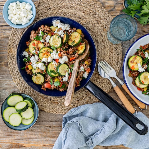 Zucchini trifft Hackfleisch, Feta und Reis – eine würzig, saftige Mischung. Schnell gemacht und prima für eine große Runde ist unsere Zucchini-Hackfleisch-Pfanne.