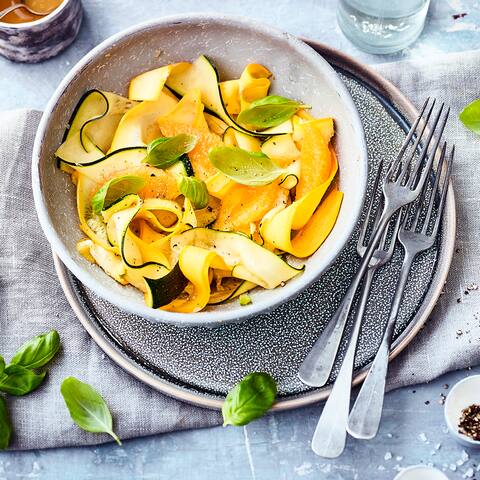 Mit unserem Zucchinisalat-Rezept stellen Sie eine einfache, aber raffinierte Vorspeise her. Orangendressing und Basilikum peppen das milde Gemüse auf.