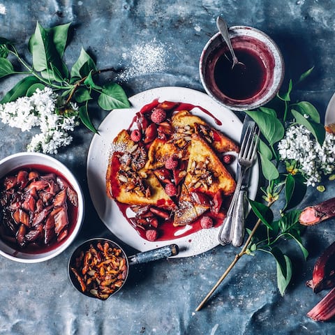 Ein fantastisches Frühstück, das den Start in den Tag zu etwas ganz Besonderem macht: Kokos-Mandel-French-Toast mit pochiertem Rhabarber und Himbeeren. 