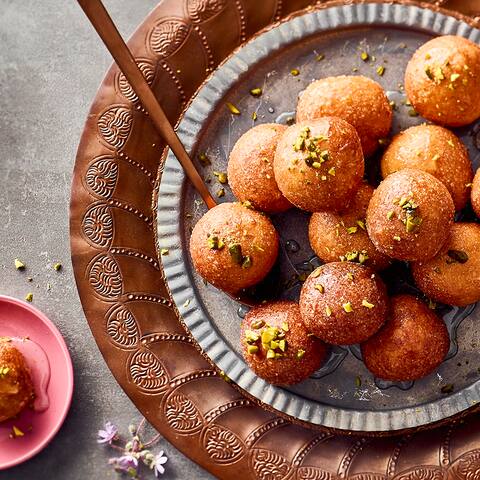 Gulab Jamun sind leckere, knusprig frittierte Milchbällchen mit Zuckersirup. Probieren Sie unser Rezept für die klassische Süßspeise aus Indien zu Hause aus!