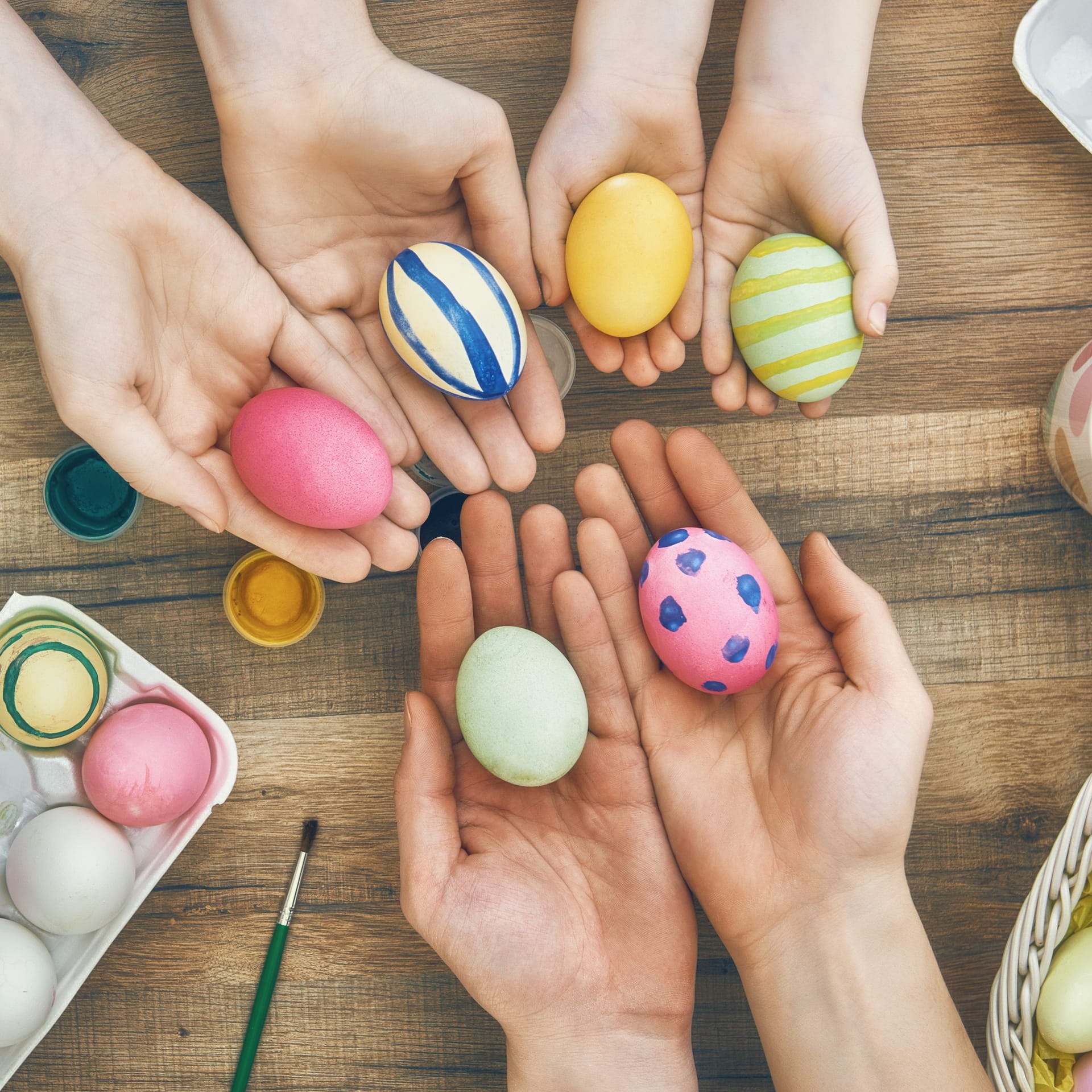 Hände präsentieren Eier beim färben auf Tisch