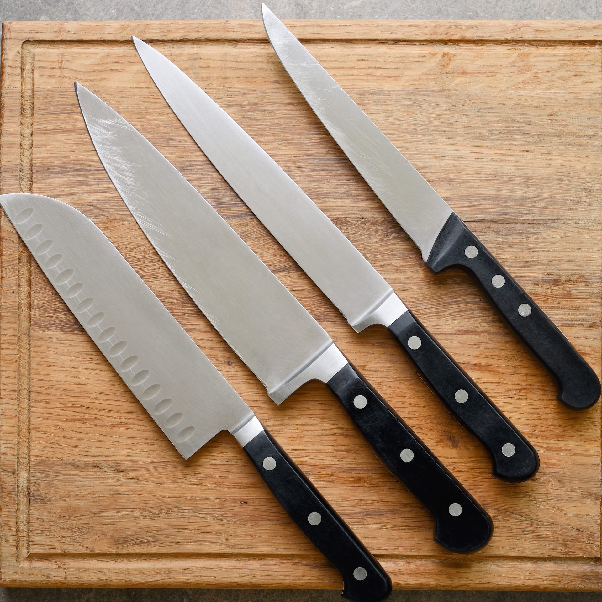 Verschiedene Messer auf einem Holzbrett.