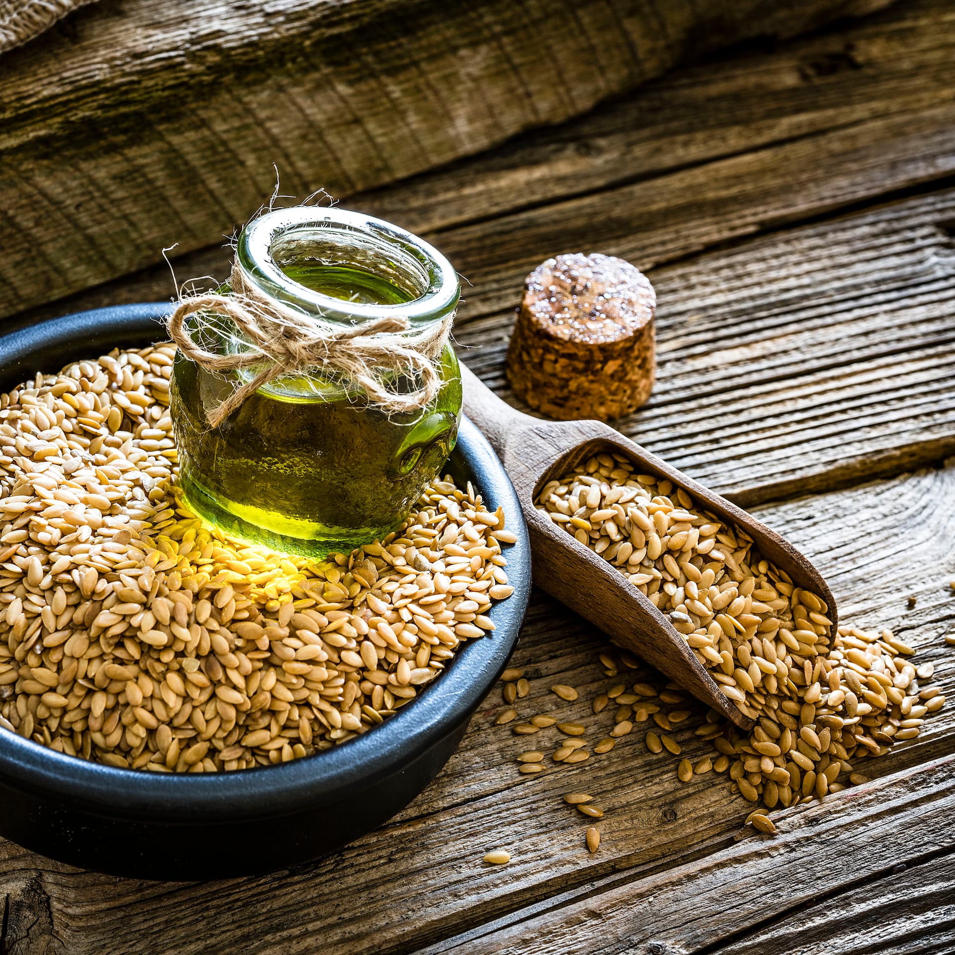 Fläschchen mit Leinöl auf Leinsamen