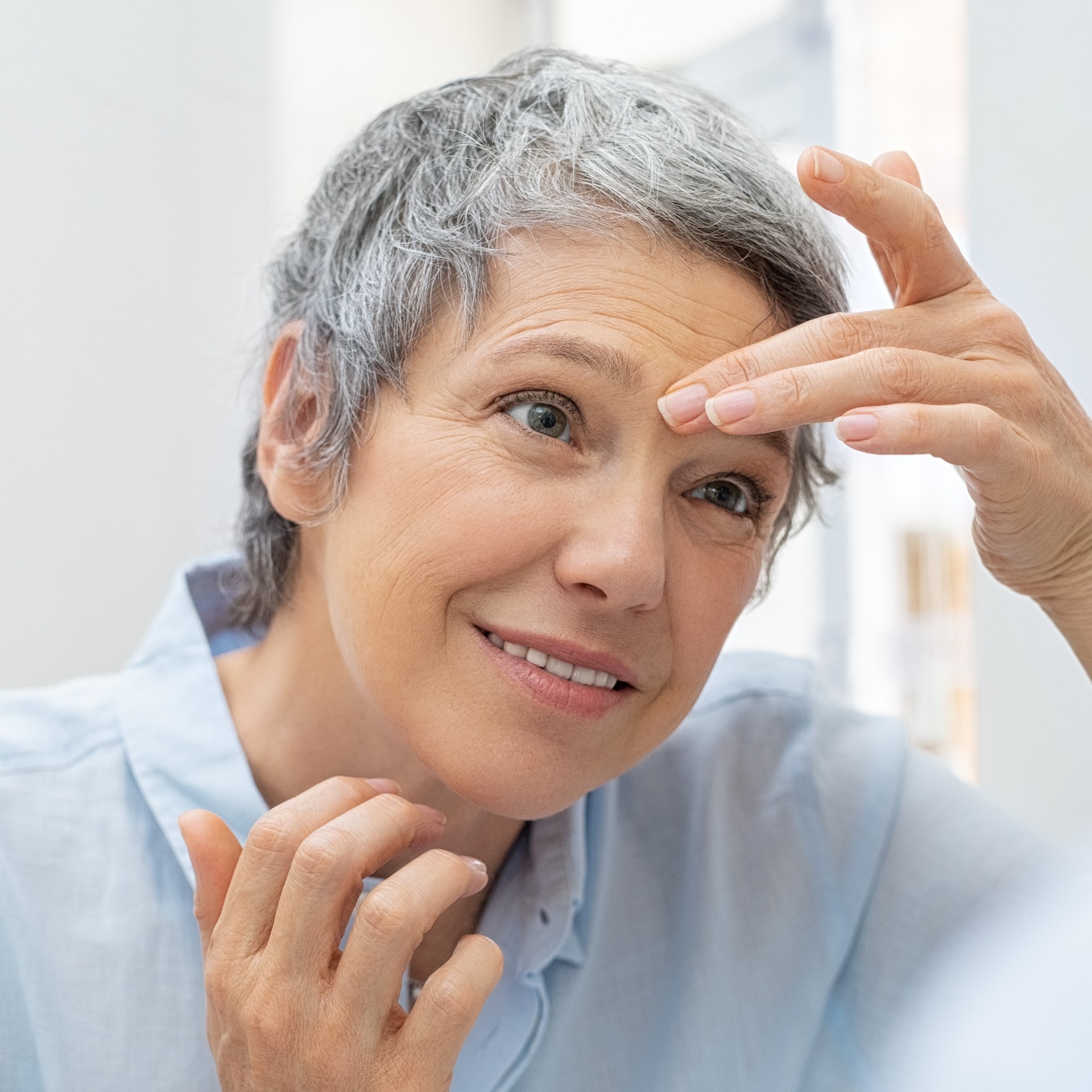 Frau massiert Augenbrauen bei Gesichtsmassage