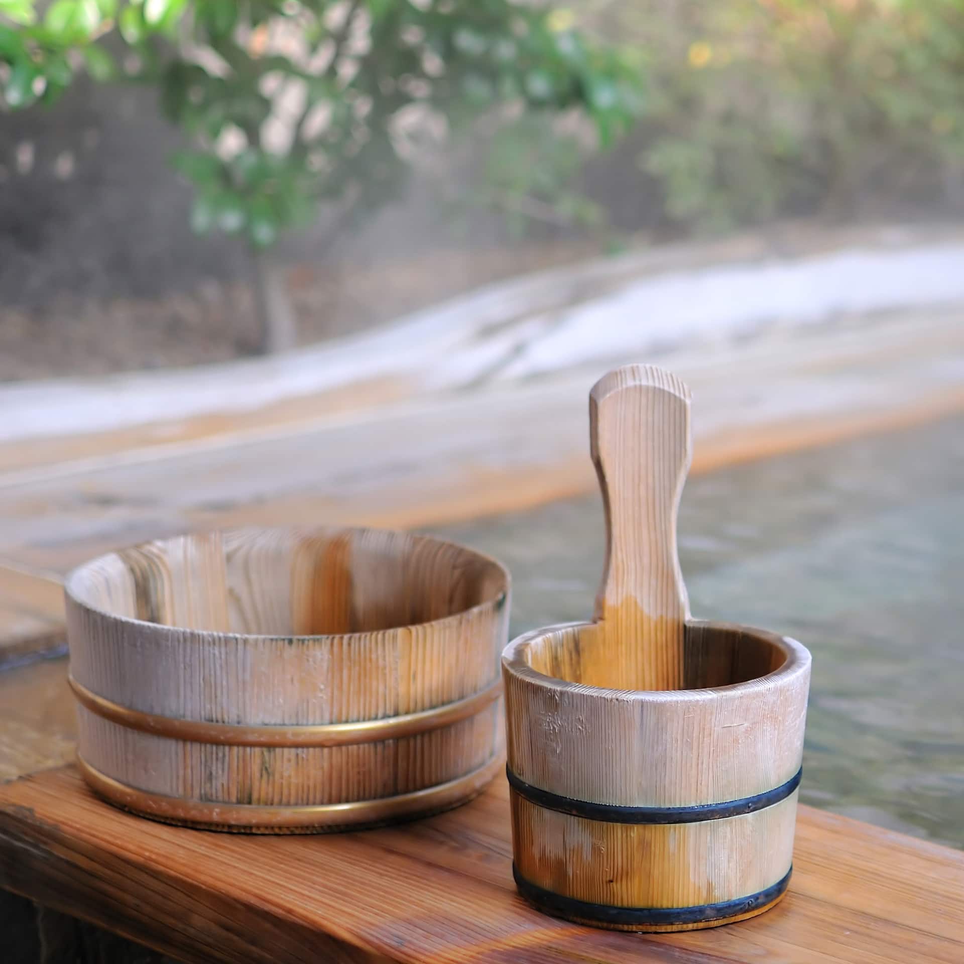 Holzeimer neben Thermalwasser Bad.