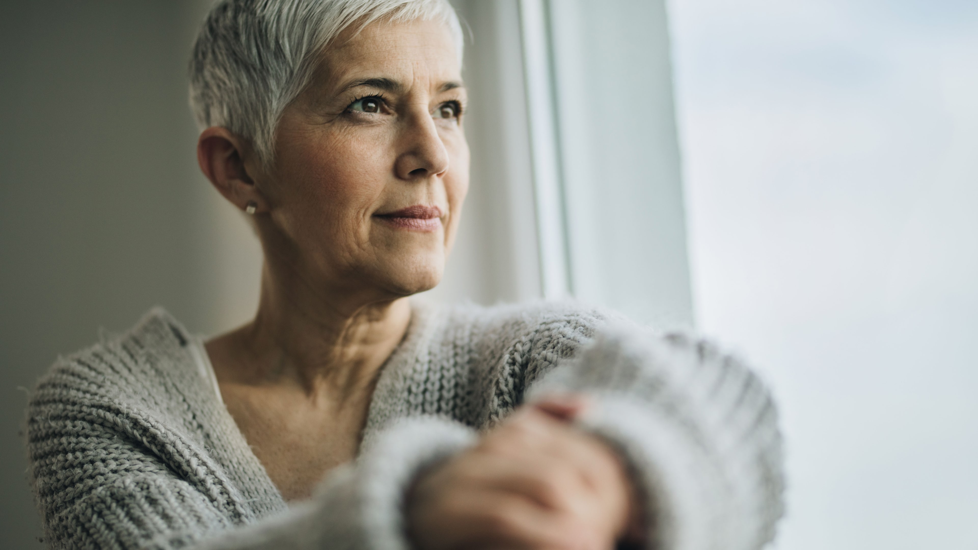 Ältere Dame sitzt am Fenster