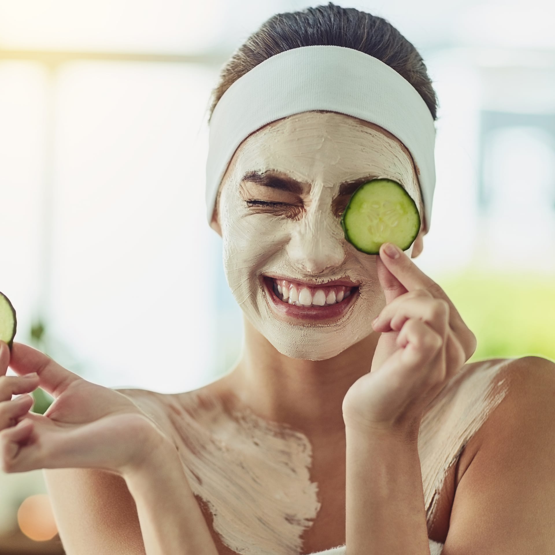 Frau mit Gesichtsmaske und Gurkenscheiben