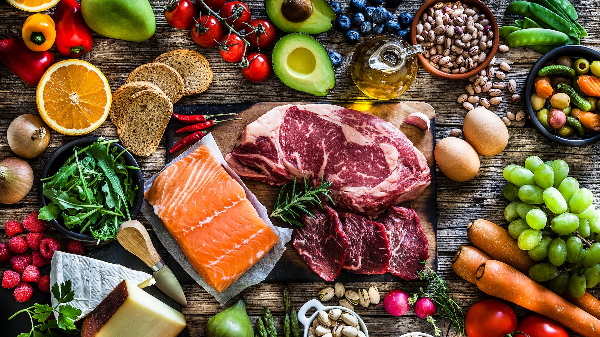 Fleisch und Fisch mit Obst und Gemüse auf Holzuntergrund 