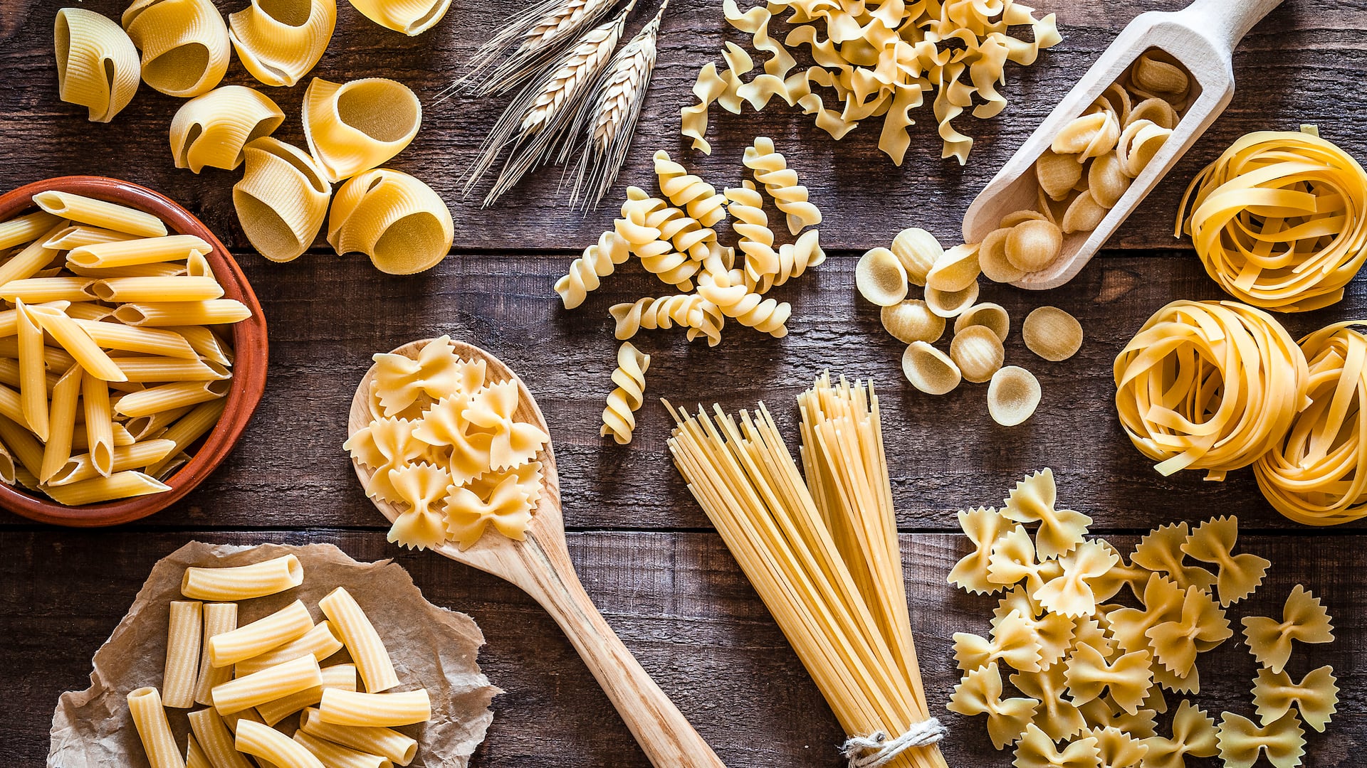 Verschiedene Nudelsorten auf dunkelm Holzuntergrund