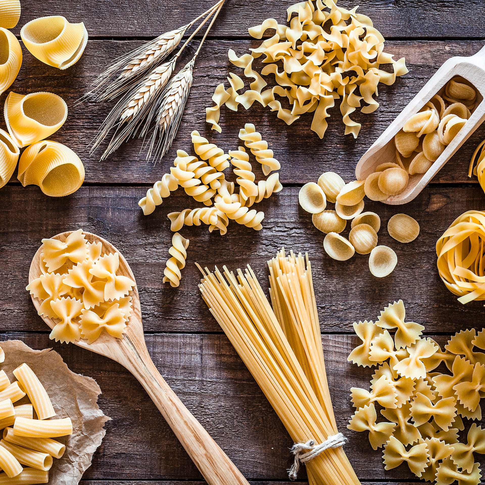 Verschiedene Nudelsorten auf dunkelm Holzuntergrund