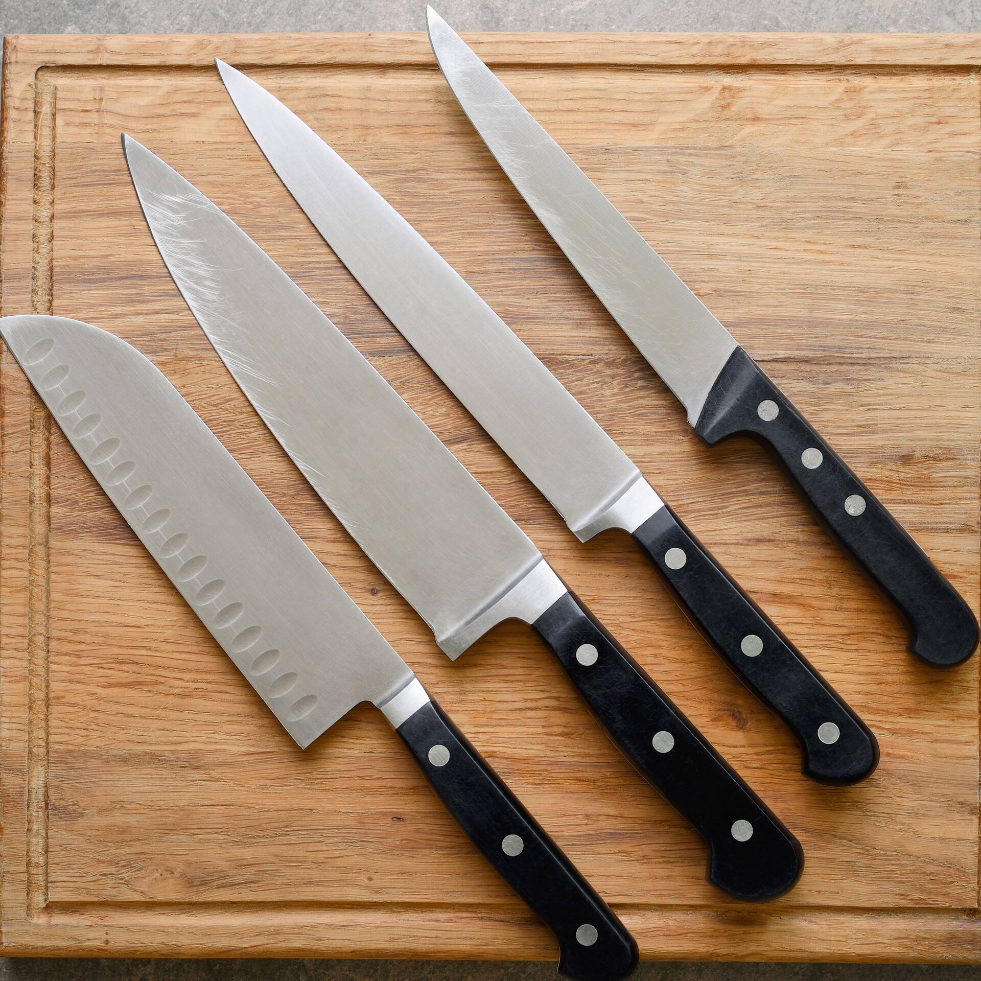 Verschiedene Messer auf einem Holzbrett.