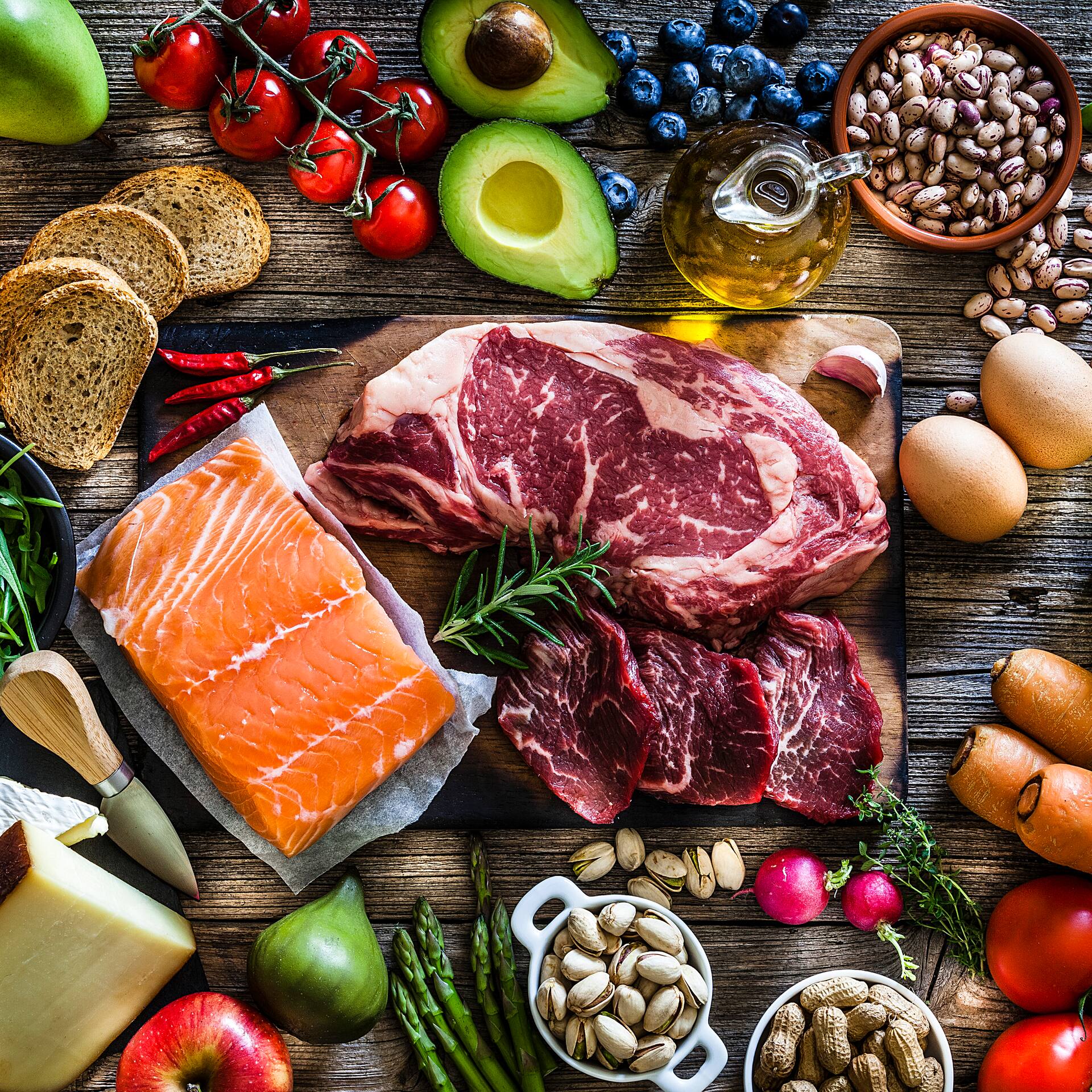 Fleisch und Fisch mit Obst und Gemüse auf Holzuntergrund