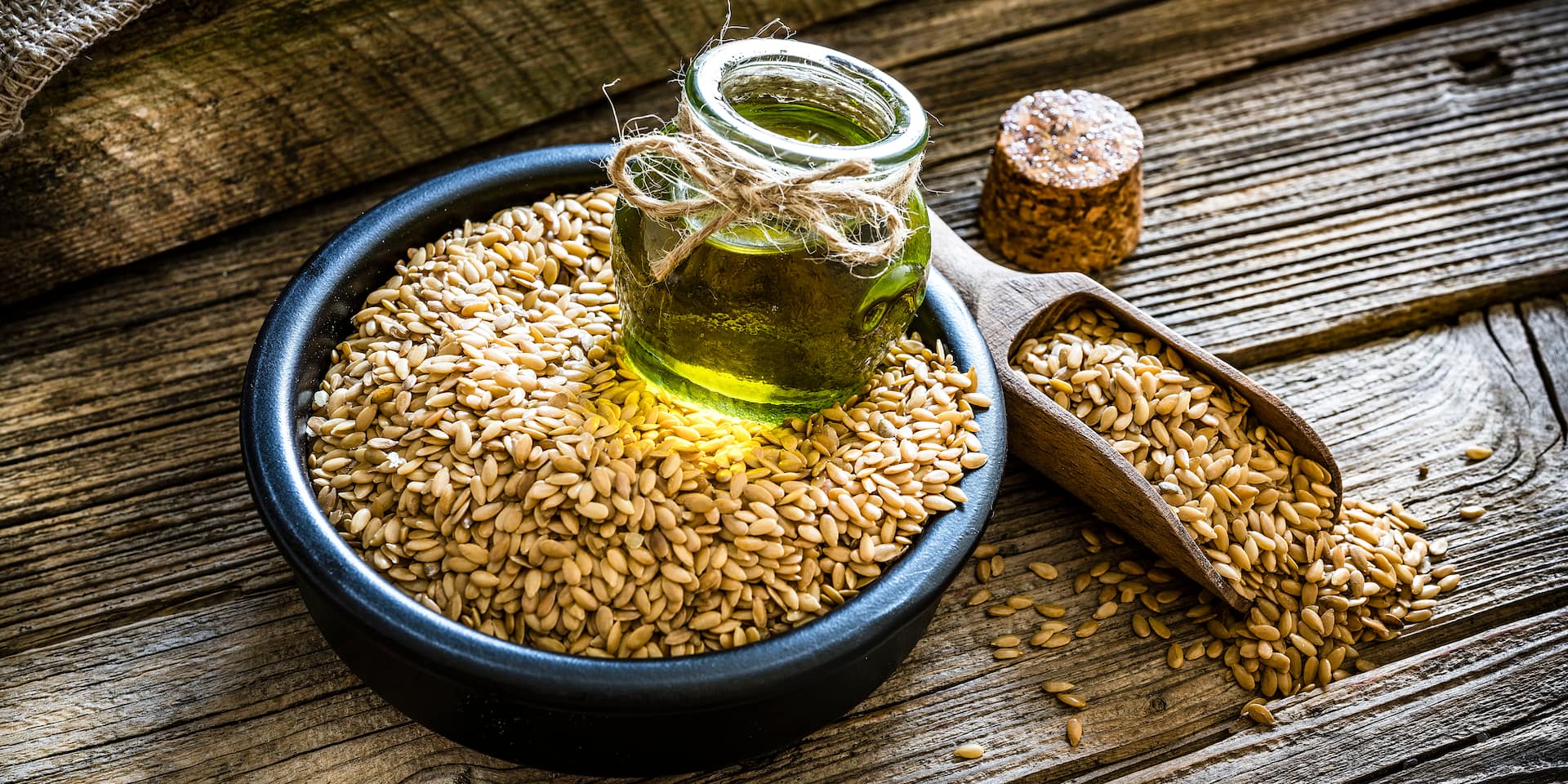 Fläschchen mit Leinöl auf Leinsamen