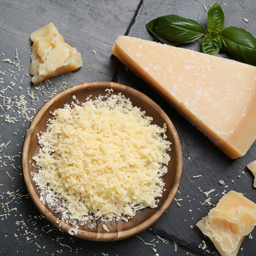 Parmesanstück und gehobelter Parmesan in Schale