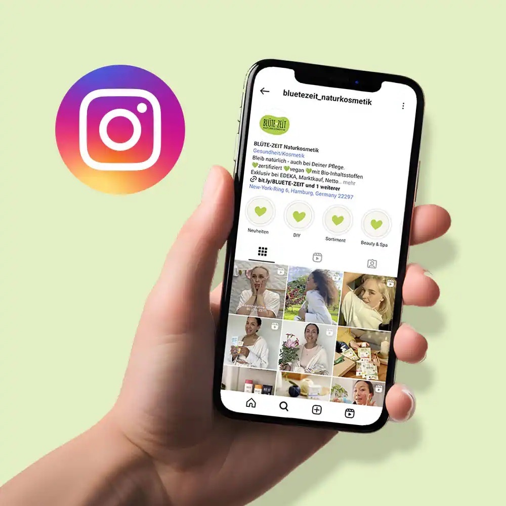 Hand hält Smartphone mit Instagram-Account von Blütezeit auf dem Screen.