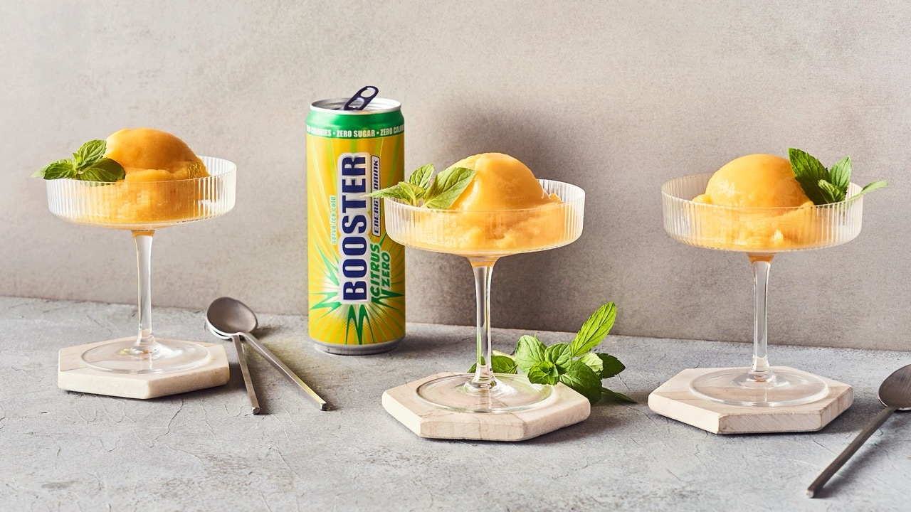 Drei Dessertschalen mit langem Stiel. Darin ein gelbes Sorbet. Im Hintergrund eine geöffnete Dose Booster Citrus Zero.