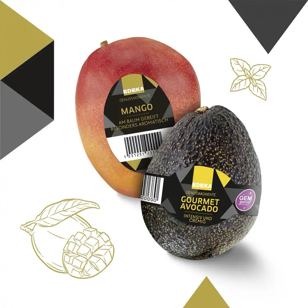 Eine rote Mango und eine ungeschälte Avocado mit Sticker von EDEKA Genussmomente.