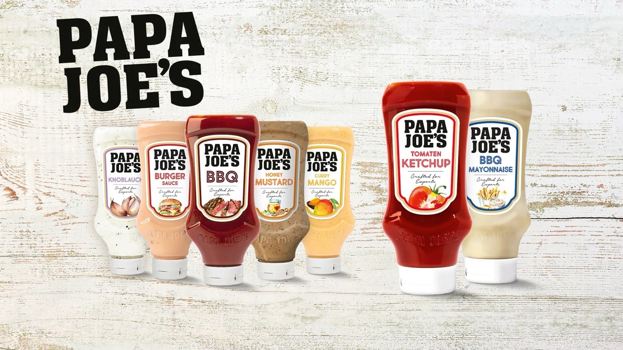 Verschiedene Saucen-, Ketchup- und Mayonnaise-Flaschen von Papa Joe's auf hellem Holzuntergrund.