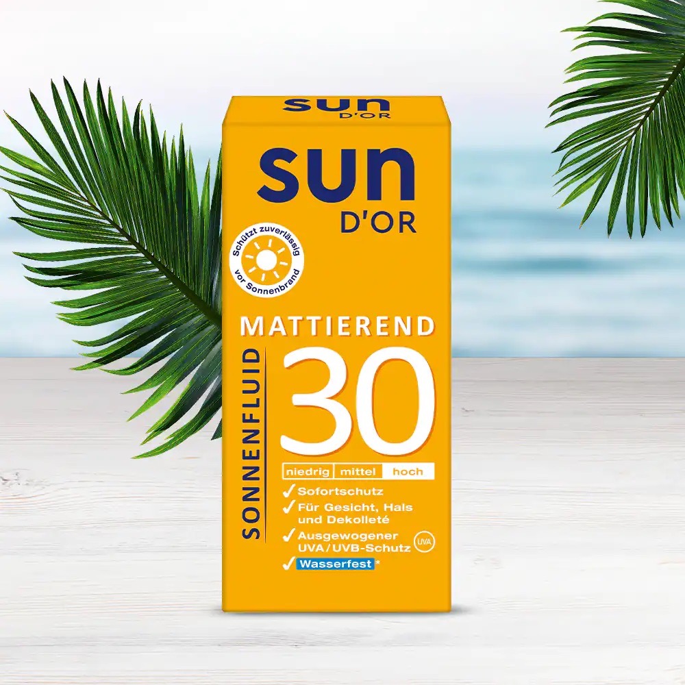 Gelbe Packung Sonnenfluid mattierend 30 von Sun D´Or. Im Hintergrund ein Strand und Horizont.