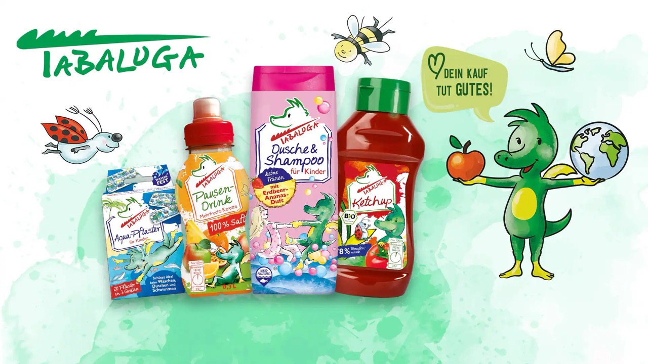 Tabaluga Kinderprodukte wie Saft, Shampoo und Ketchup neben der grünen Drachenfigur Tabaluga.