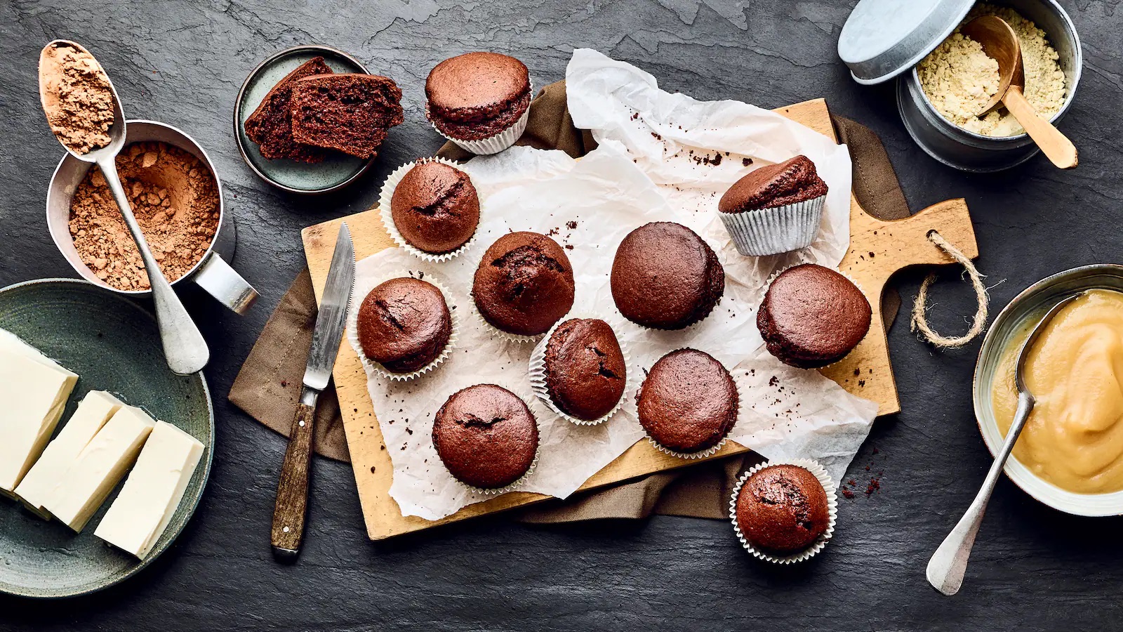 Braune Muffins und die dazugehörigen Zutaten.