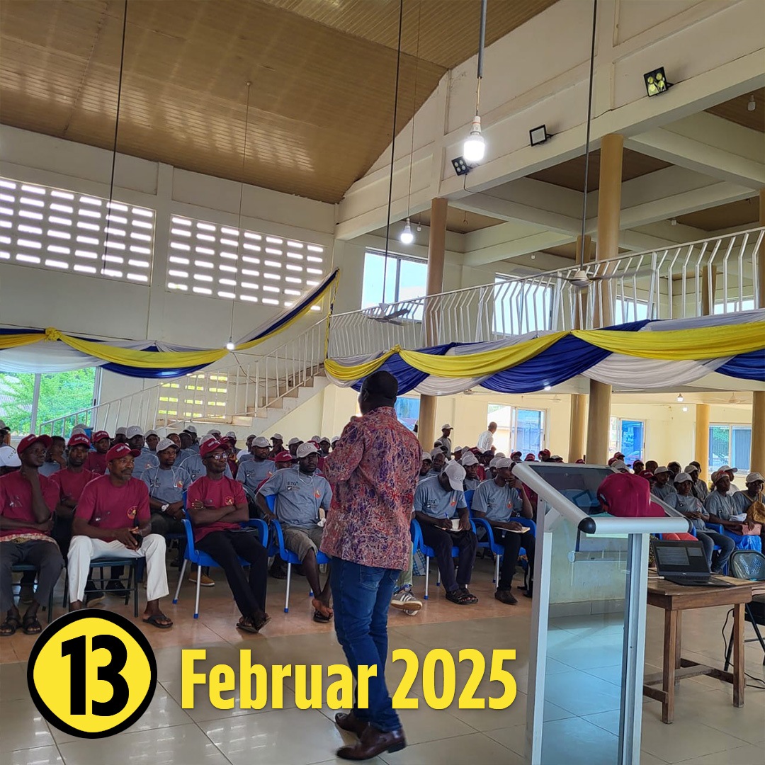 Ein Raum mit Menschen, die sitzend einer Person zuhören