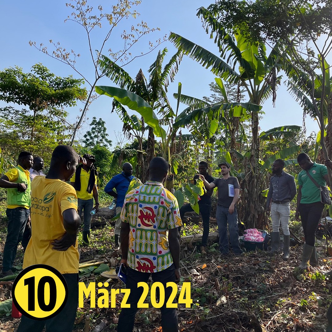 Mehrere Menschen stehen zusammen in einem Kreis und hören einer Person zu