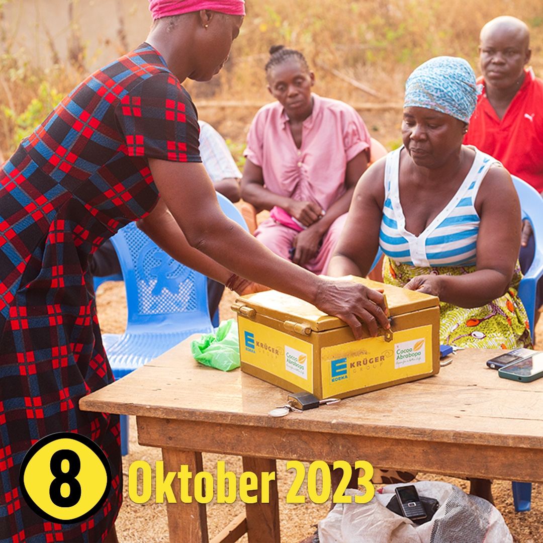 Eine Frau sitzt an einem Tisch, darauf eine EDEKA Kasse. Eine andere Frau greift zur Kasse.