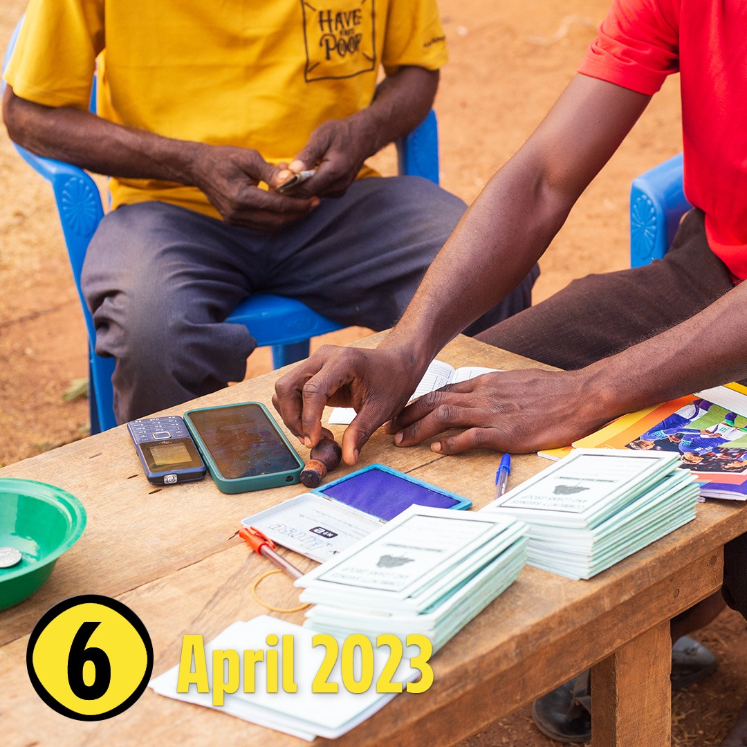 Auf einem Tisch liegen Stifte, Notizblöcke und  Smartphones zur Bildung von Kleinkredit-Spargruppen