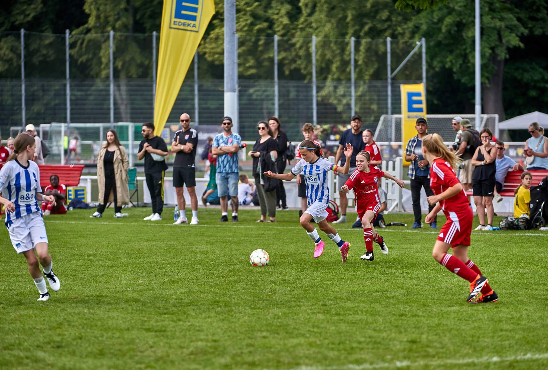 Zwei junge Fußball-Spielerinnen rennen dem Ball hinterher.