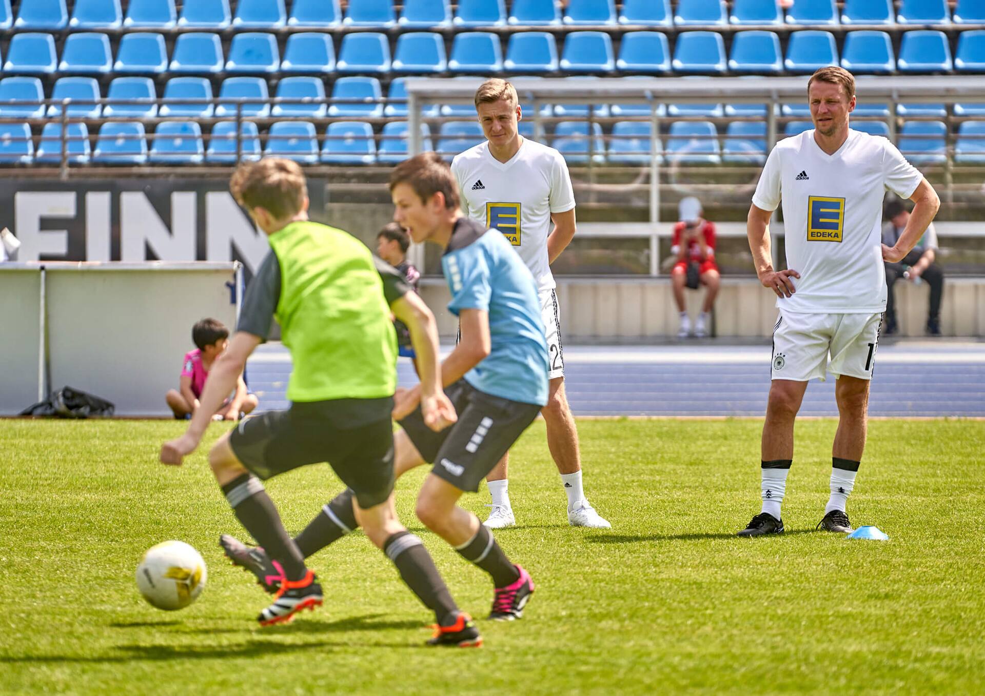Die Ex-Profis Felix Kroos und Maik Franz schauen bei den Übungen eines männlichen Jugend-Fußballteams zu.