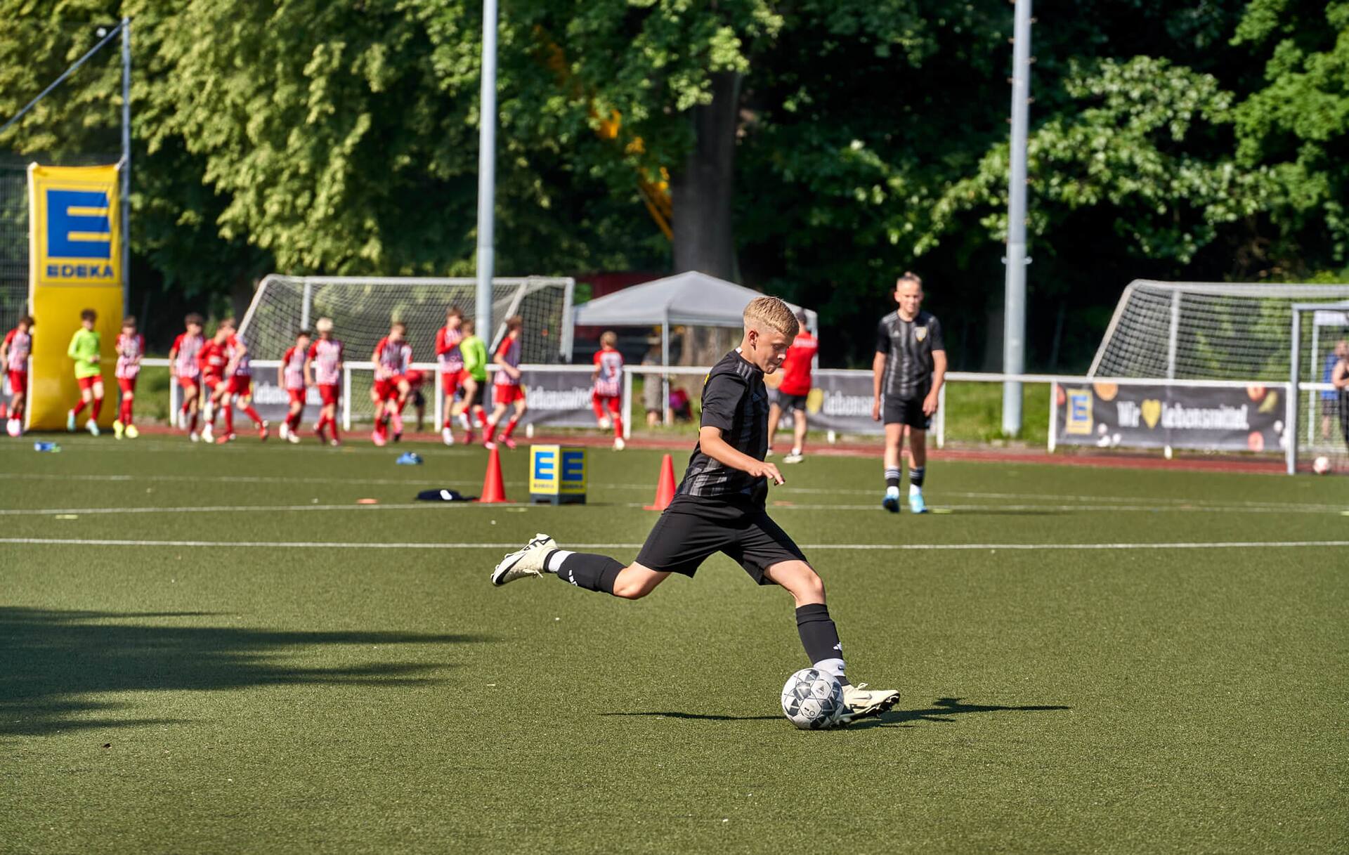 Ein Spieler in schwarz tritt unbedrängt gegen den Ball.